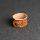 Brown leather ring with a gold button