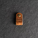 Brown leather tag with a gold rivet 